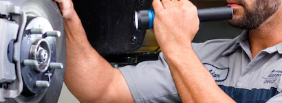 Hyundai technician inspecting brake pads and tires at McCarthy Hyundai of Lawrence KS